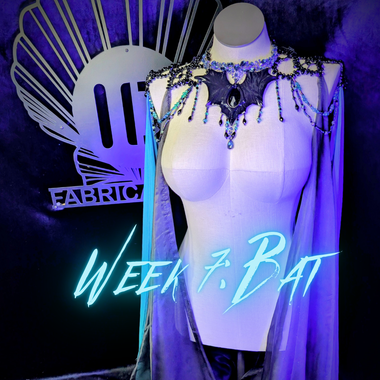 Mannequin wearing a decorative costume with 'Fabric' logo and 'Week 7 Bat' text in the background