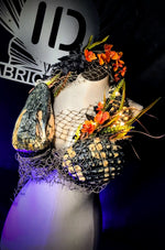 Mannequin wearing a decorative headpiece and mermaid top with flowers and netting, against a dark background with 'ID' branding.