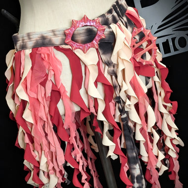 Mannequin wearing a colorful ruffled skirt with a brand logo in the background