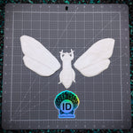 White moth-shaped mold on a grid surface with 'ID Fabrics' logo.