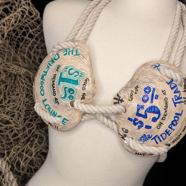 Mannequin wearing a bra made of rope with text on it, against a dark background.