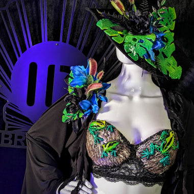 Mannequin wearing a colorful embroidered bra and headpiece with a dark background