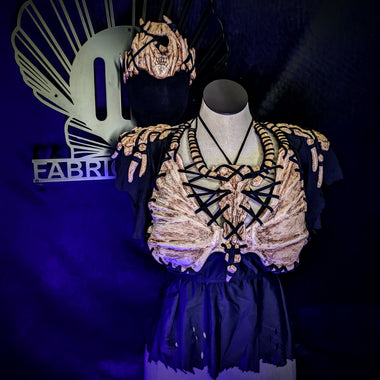 Mannequin wearing a decorative outfit with a matching mask on a dark background, branded 'ID FABRICATIONS'.