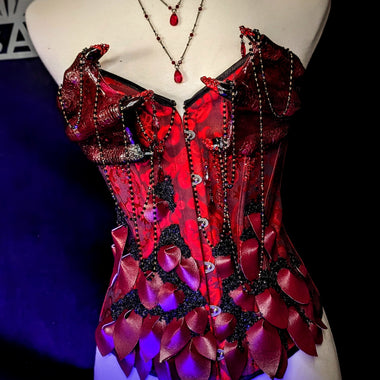 Red corset with decorative elements on a mannequin against a dark background