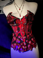 Red corset with decorative elements on a mannequin against a dark background