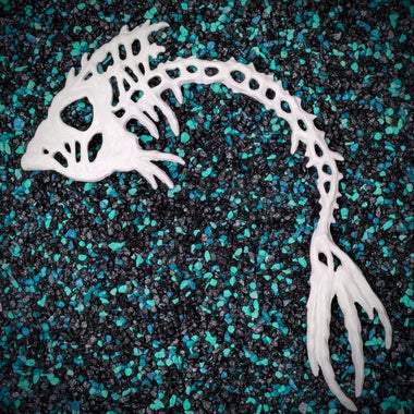 Stillwater Release the Kraftin' Bone Fish white resin plastic DIY mermaid accessory on teal and black aquarium rocks