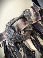 Close-up of a decorative belt with intricate design on a neutral background