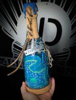 Hand holding ID fabrications OCtopus in a bottle with metal name tag