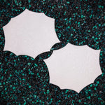 Two white circular objects on a black and green speckled surface Giant Isopod Shoulder Armor Plates ID Fabrications
