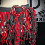 Red and black ruffled skirt on a mannequin with a brand logo in the background