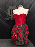 A whimsical red and black costume skirt with a conch shell buckle, designed to resemble seaweed, displayed on a mannequin.