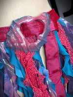 Close-up of a colorful costume with red and blue patterns on a beige background