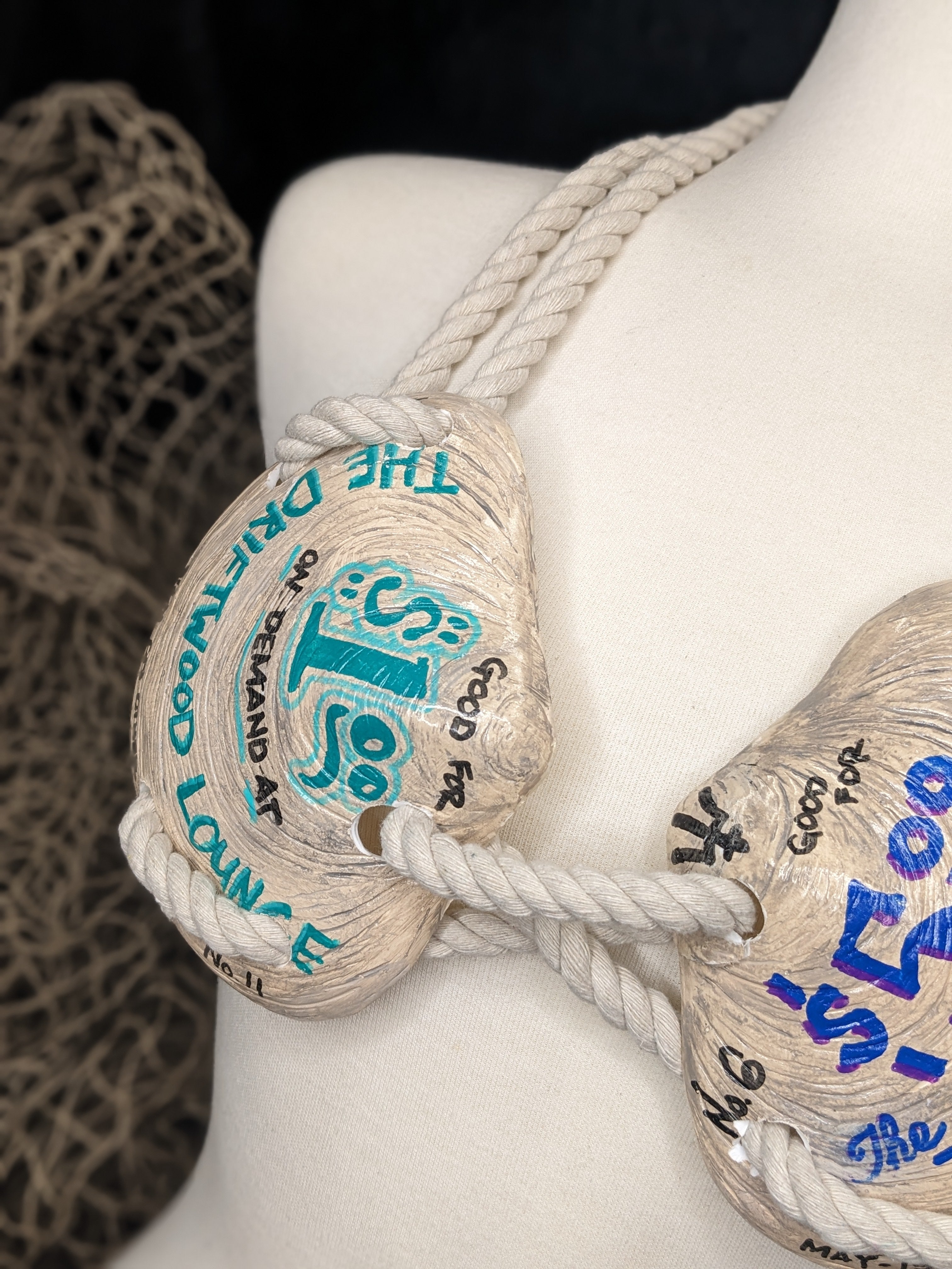 Rope with branded tags tied around a mannequin bust.