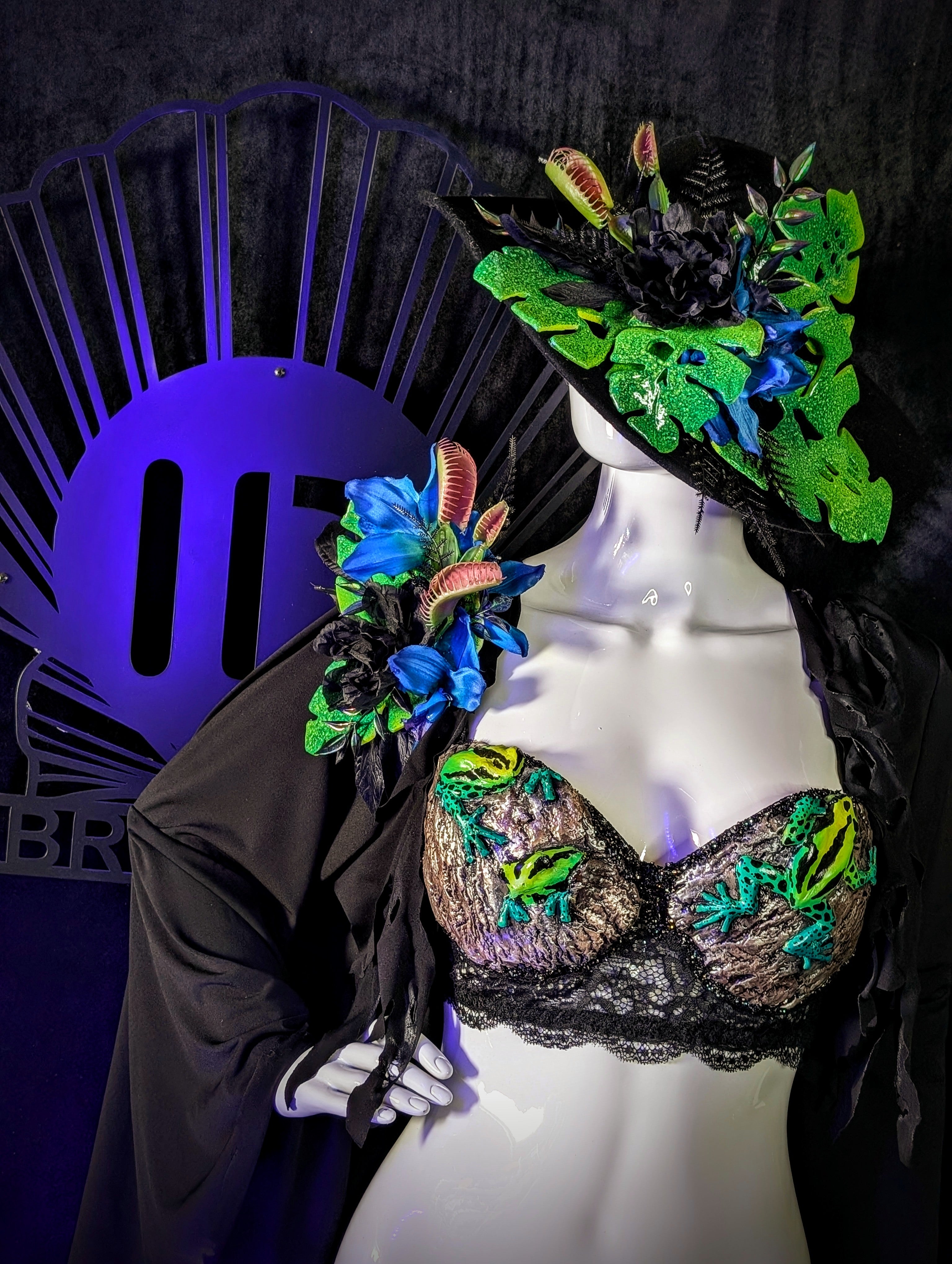 Mannequin wearing a colorful embroidered bra and headpiece with a dark background