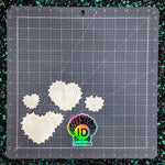 Cutting mat with heart-shaped cutouts and ID Fabrics logo.