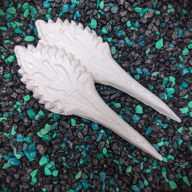 White shell-like object on a textured black and green surface