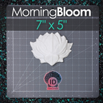 A white hand sculpted lotus flower mermaid top component resin plastic show on a gray gridded cutting mat with the MorningBloom brand name and '7" x 5"' text at the top, plus an ID Fabrics logo near the bottom.