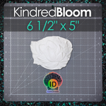 A white plastic flower for mermaid tops shown on a gray cutting mat with measurement markings. The image includes a 'KindredBloom' banner at the top and an 'ID Fabrications' logo at the bottom, with size text reading '6 1/2" x 5"'.