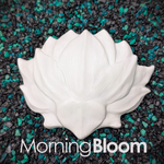 A white resin plastic lotus-shaped DIY mermaid top component, photographed from above on a bed of black and teal pebbles. The style name 'MorningBloom' is printed in white text at the bottom.
