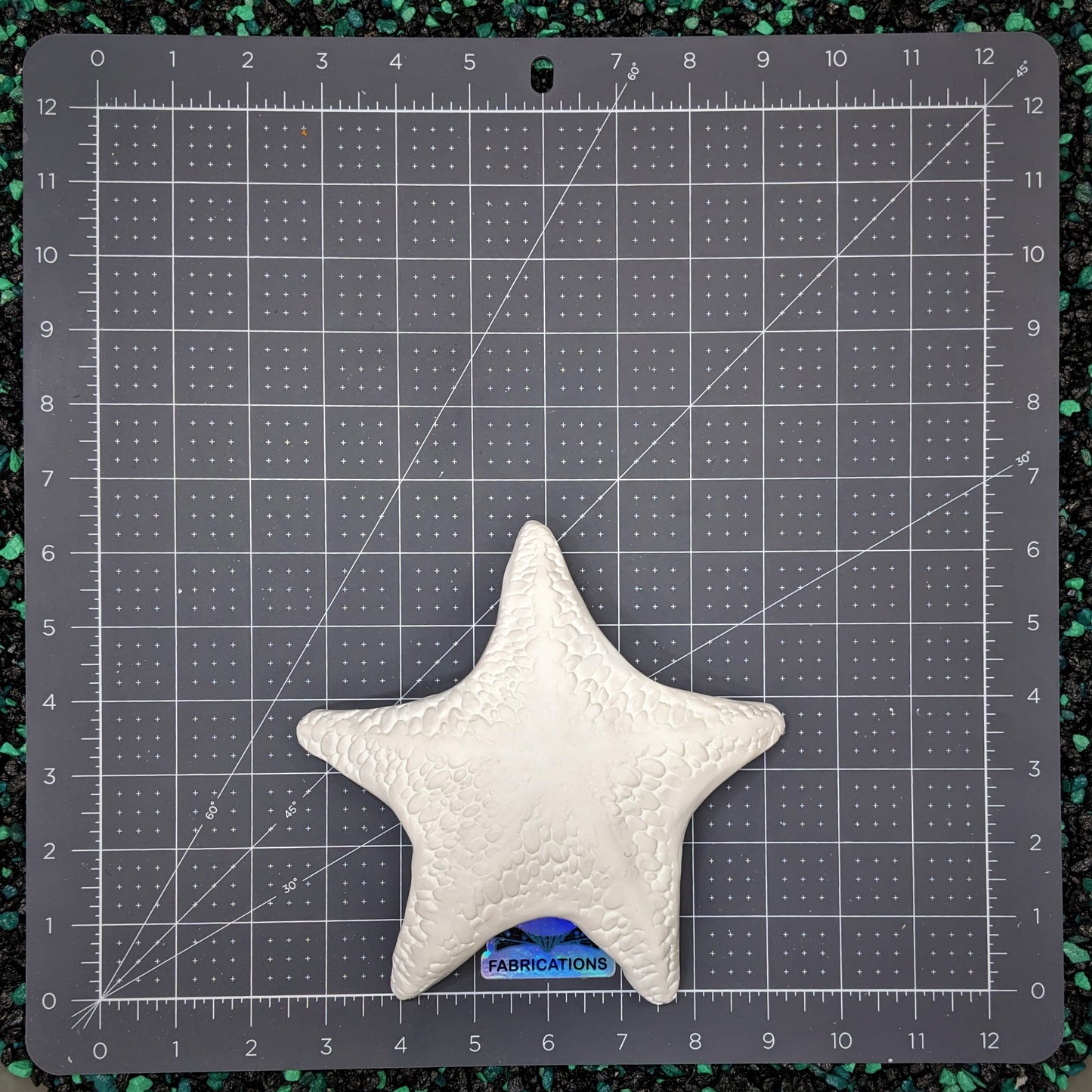 Hard plastic mermaid top starfish shells paintable on teal and black aquarium rocks and flat grey cutting mat inches measurement
