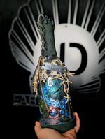 Hand holding ID fabrications OCtopus in a bottle with metal name tag