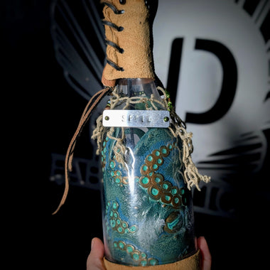 Hand holding ID fabrications OCtopus in a bottle with metal name tag