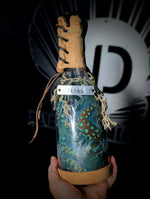 Hand holding ID fabrications OCtopus in a bottle with metal name tag