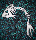 Stillwater Release the Kraftin' Bone Fish white resin plastic DIY mermaid accessory on teal and black aquarium rocks