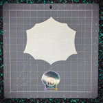 White shoulder plate on a gray cutting mat with grid lines